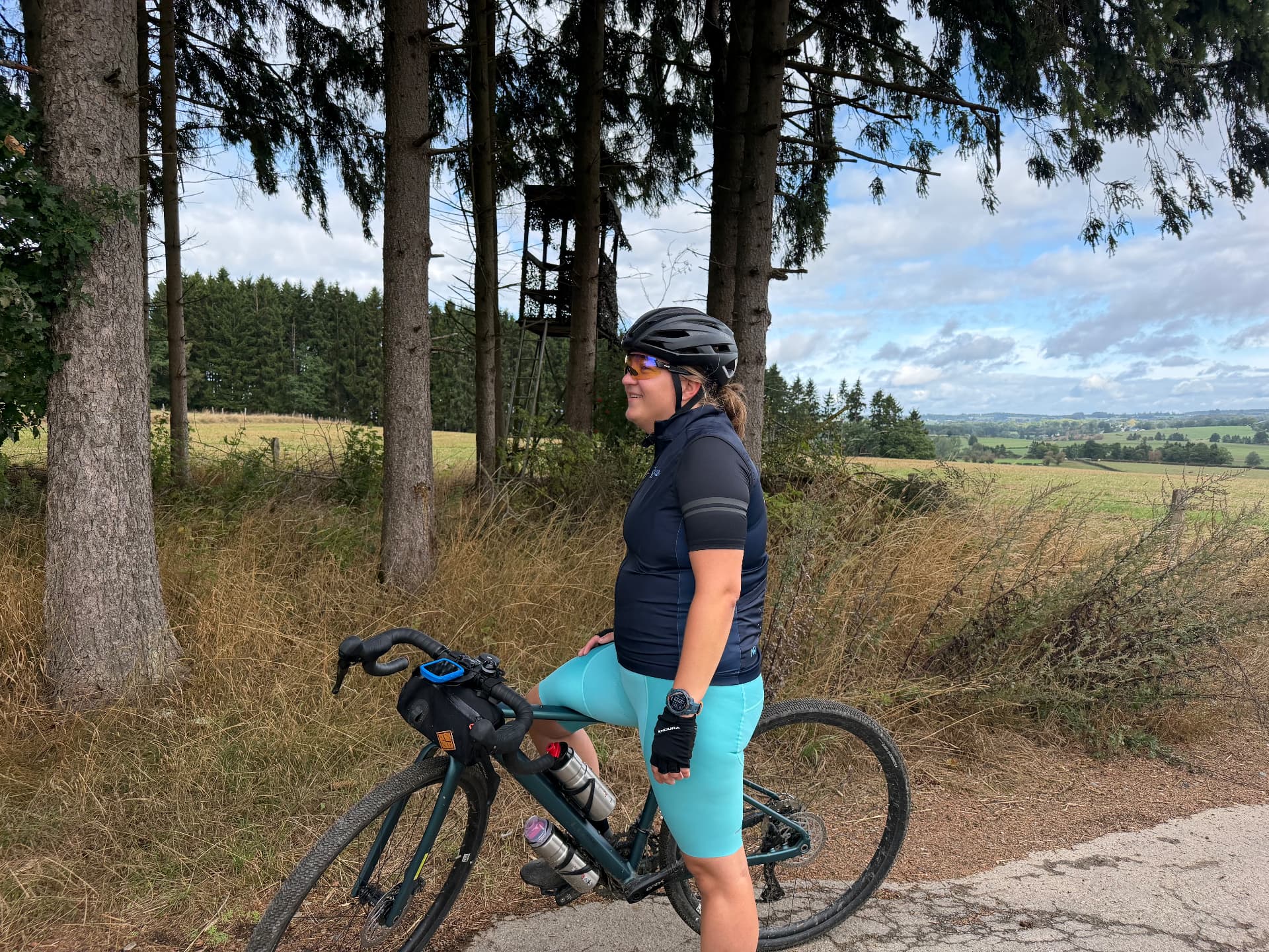 Sfeer van een eerdere Fietsvrouwen-rit in de Ardennen: een deelneemster kijkt uit over het heuvellandschap