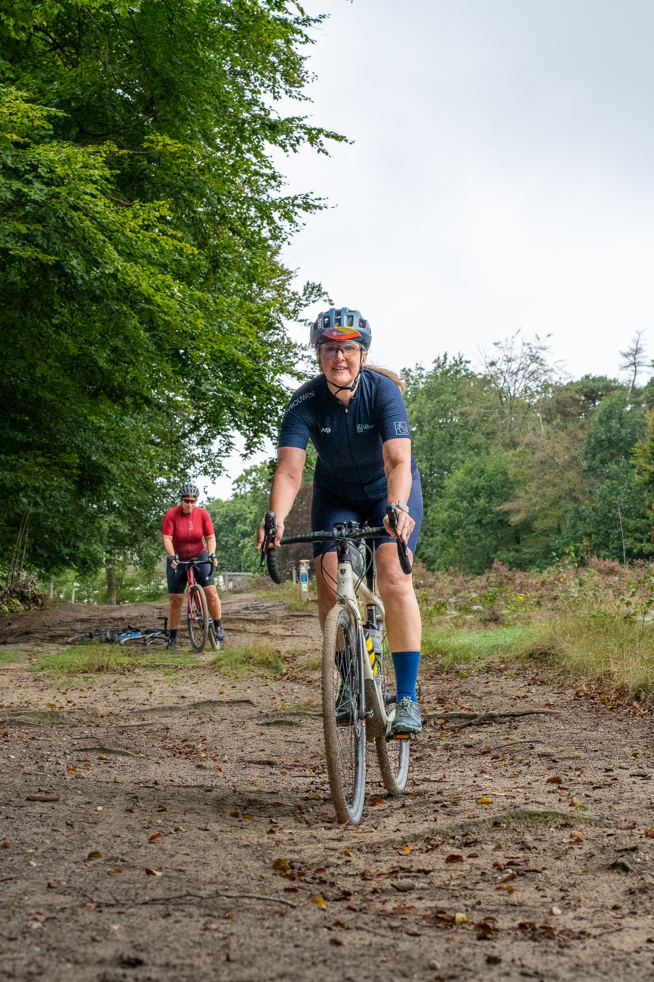 Lachende deelneemster op haar gravelbike op een zandpad