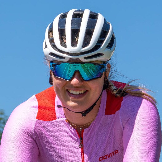 Kirsten Boerrigter, founder of Cyclingwomen, smiling on her bike in the mountains