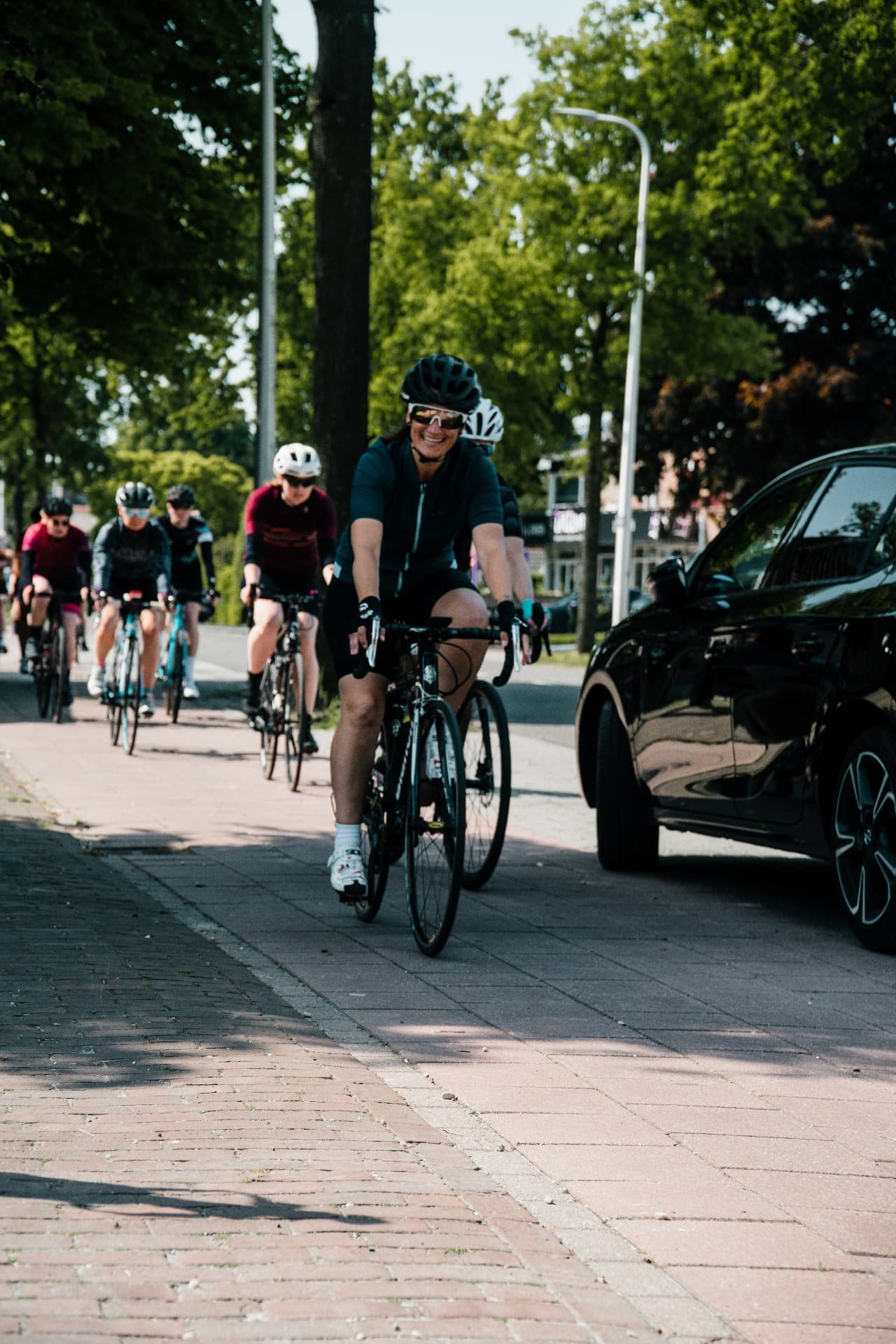Lachende deelneemster met Fietsvrouwen achter haar tijdens een clubrit in Nijverdal