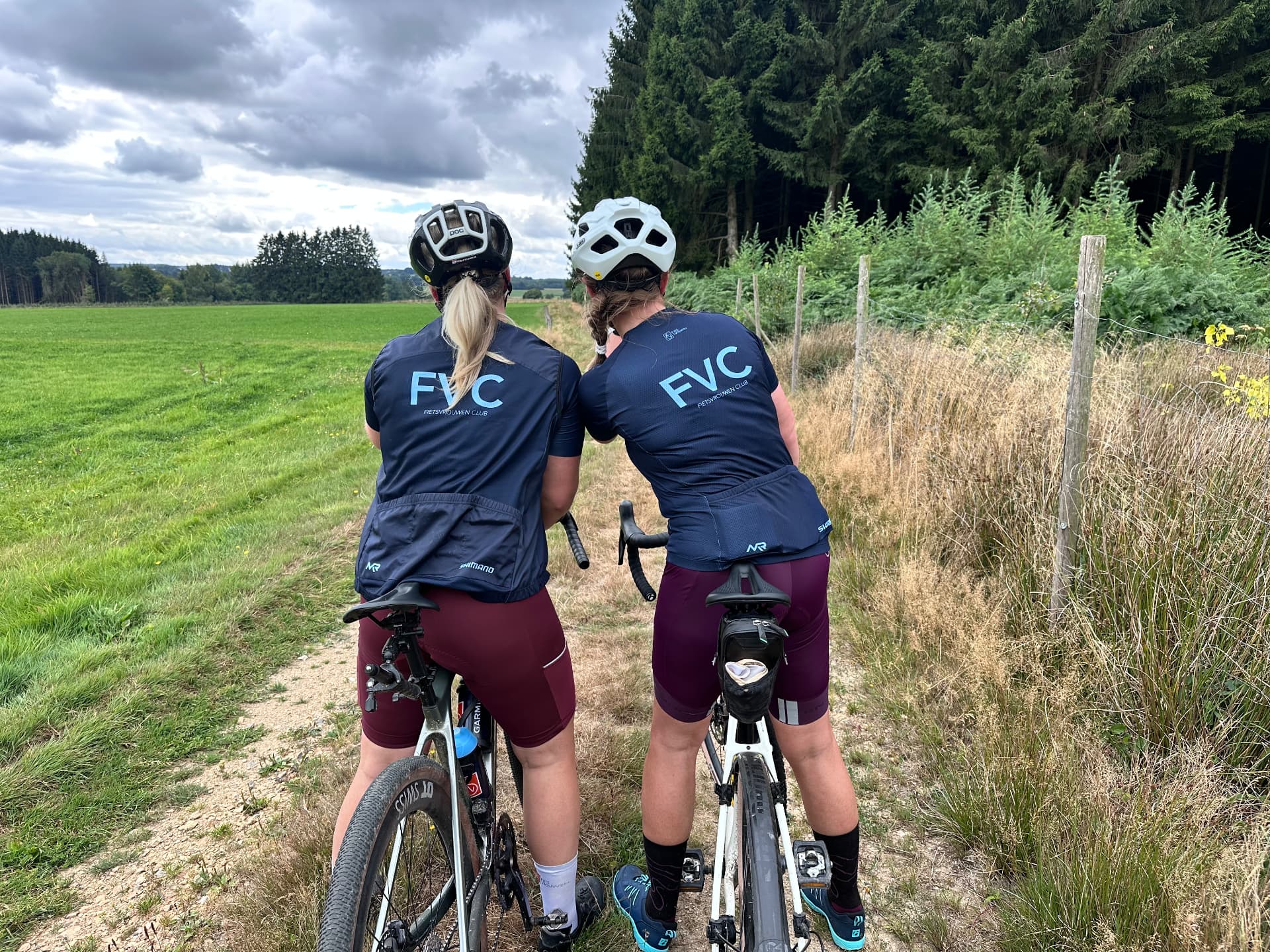 Sfeer van een eerdere Fietsvrouwen-rit in de Ardennen: twee deelneemsters in FVC-shirts genieten van het uitzicht