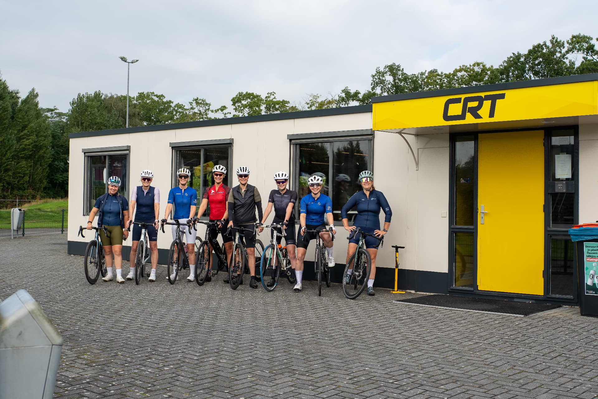 Groepsfoto van deelneemsters met hun fietsen voor de start van een clubrit