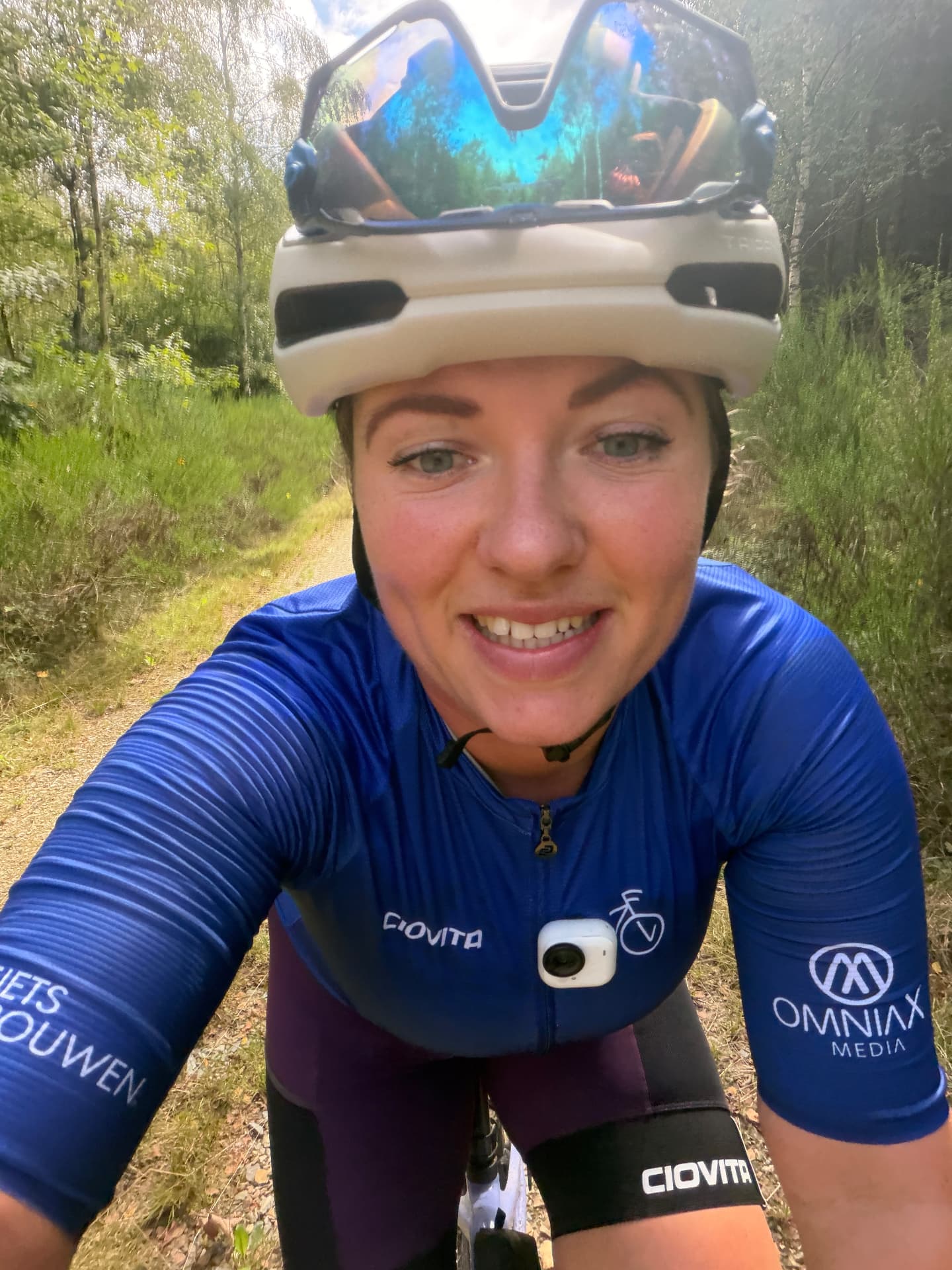 Sfeer van een eerdere Fietsvrouwen-rit in de Ardennen: selfie van een lachende deelneemster op de fiets