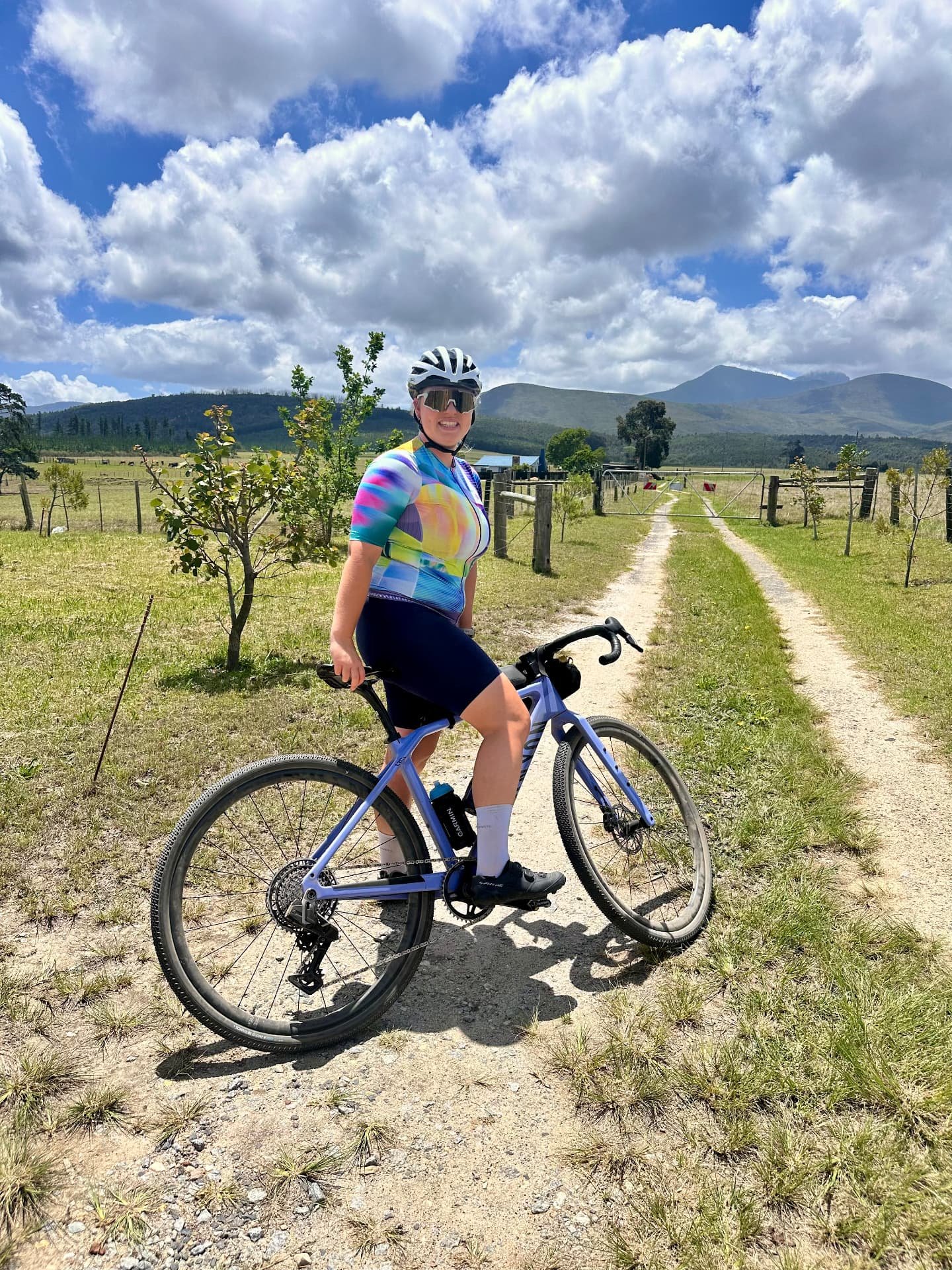 Cycling woman on her gravel bike on a country road between mountains