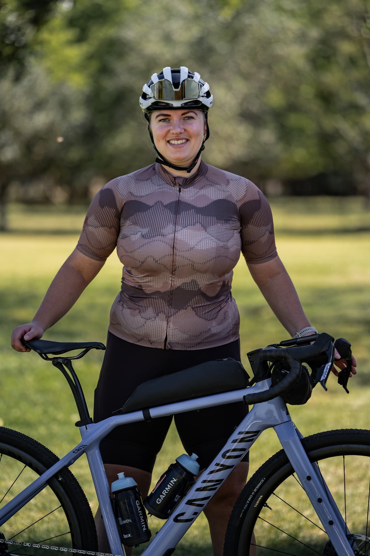 Smiling Cycling woman with helmet and gravel bike