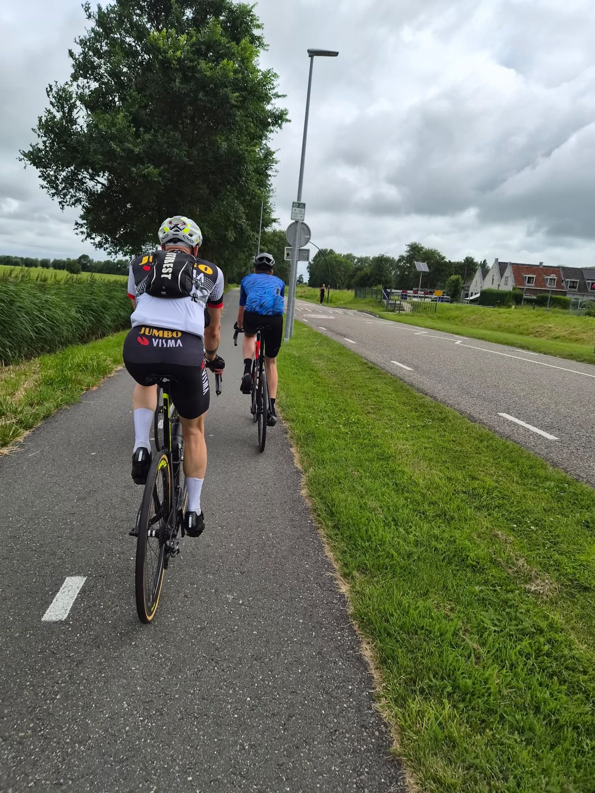 Twee racefietsers op een fietspad tussen de weilanden van het Groene Hart tijdens de Tour d’Utrecht