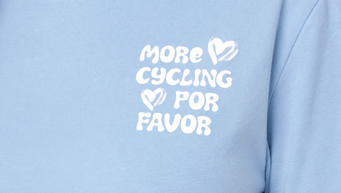 Fietsvrouw draagt het lichtblauwe Fietsvrouwen t-shirt met de tekst More Cycling Por Favor